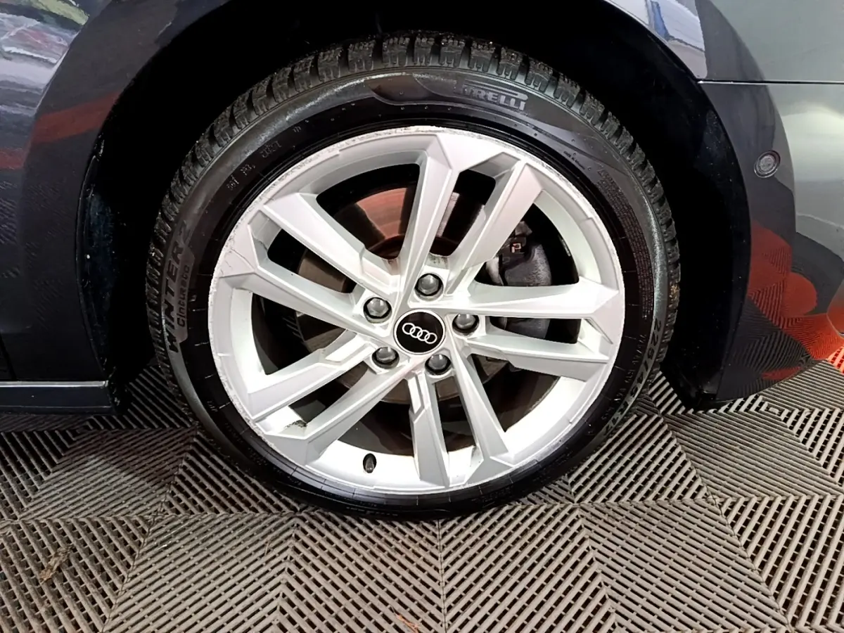 Gros plan sur la roue avant gauche gris foncé d’une Audi A3 35 TFSI 150 MHEV avec jante alliage à 5 doubles branches.