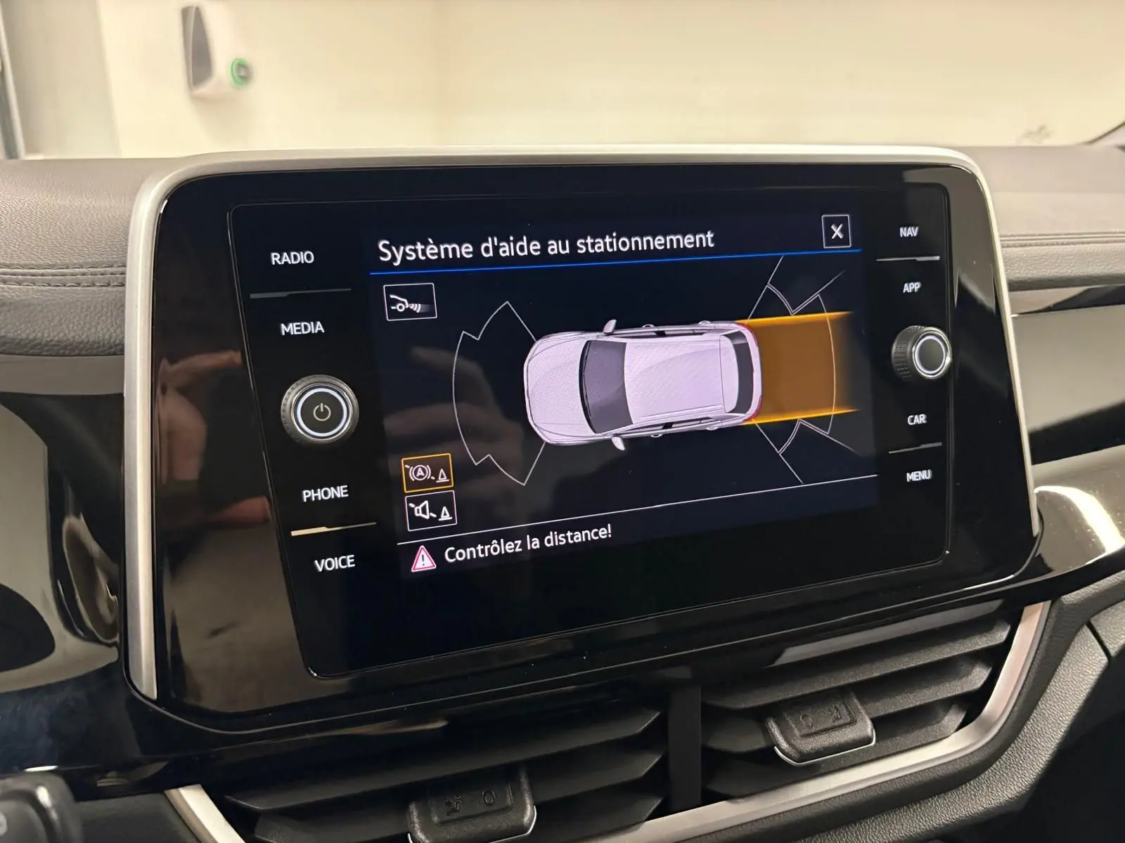 Écran central du système d'aide au stationnement du Volkswagen T-Roc 2025, affichage en vue de dessus du véhicule.