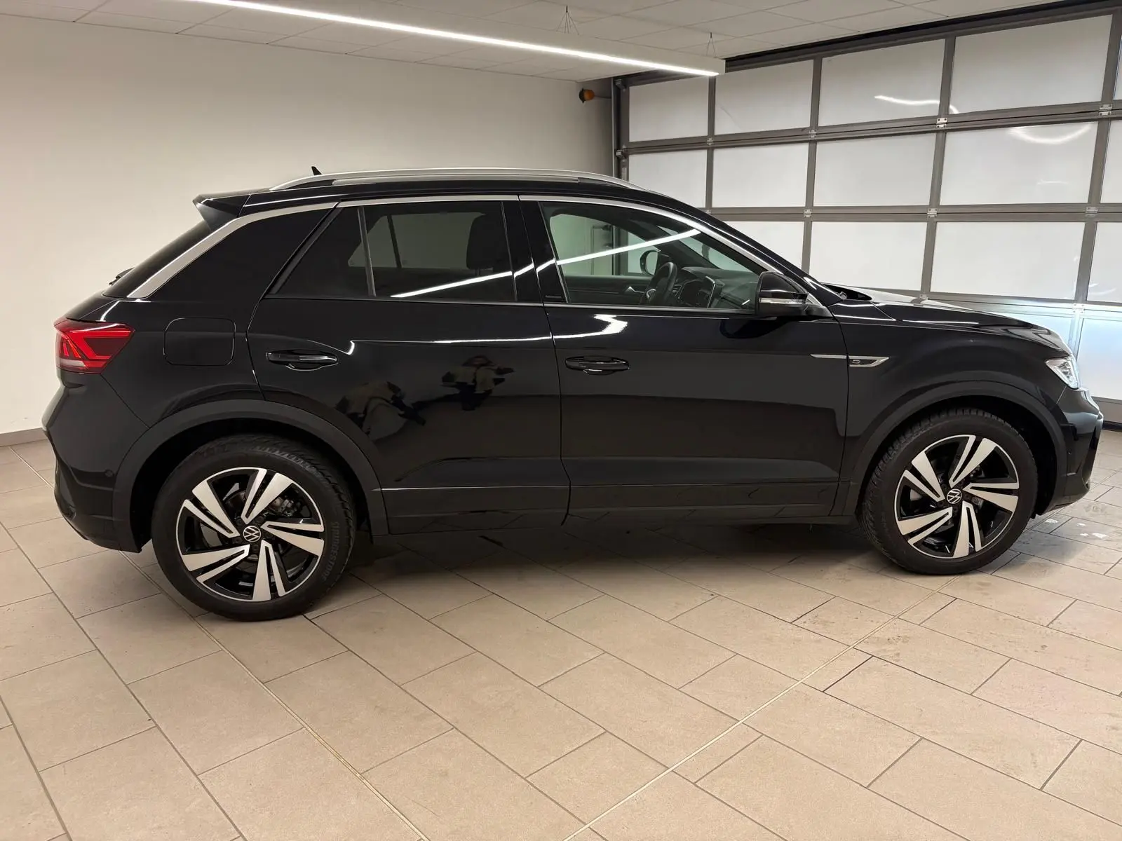 Profil côté gauche du Volkswagen T-Roc noir intense 2025 en finition R-Line, avec jantes alliage distinctives.