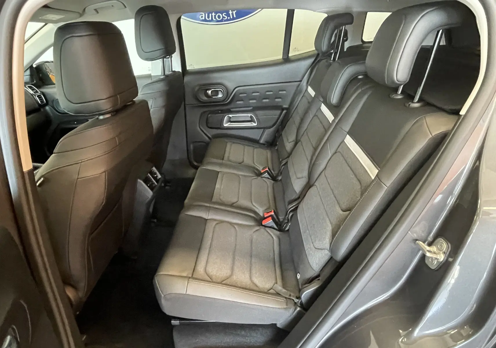 Vue intérieure côté droit des sièges arrière gris tissu/TEP du Citroën C5 Aircross hybride 2025 avec portes ouvertes.