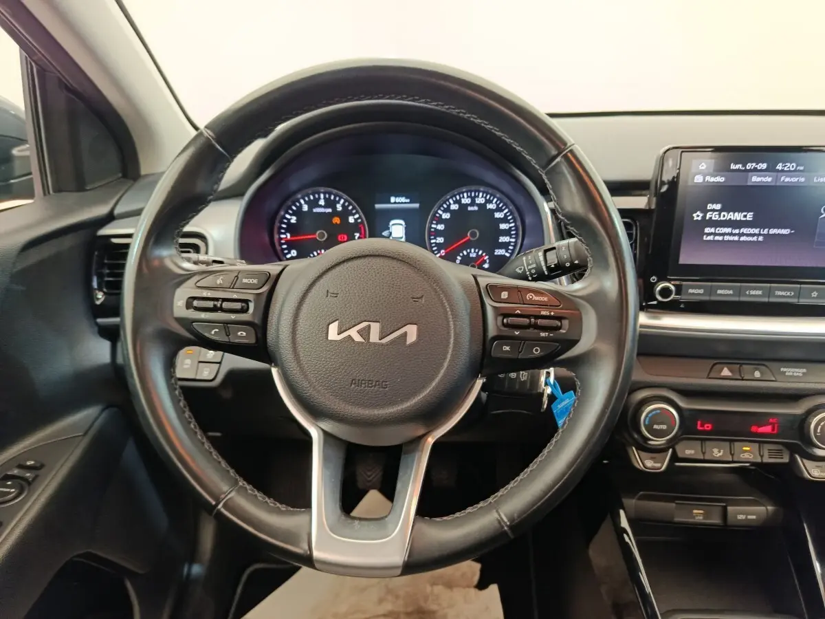 Vue intérieure centrée sur le volant cuir noir et le tableau de bord digital du Kia Stonic 2023.