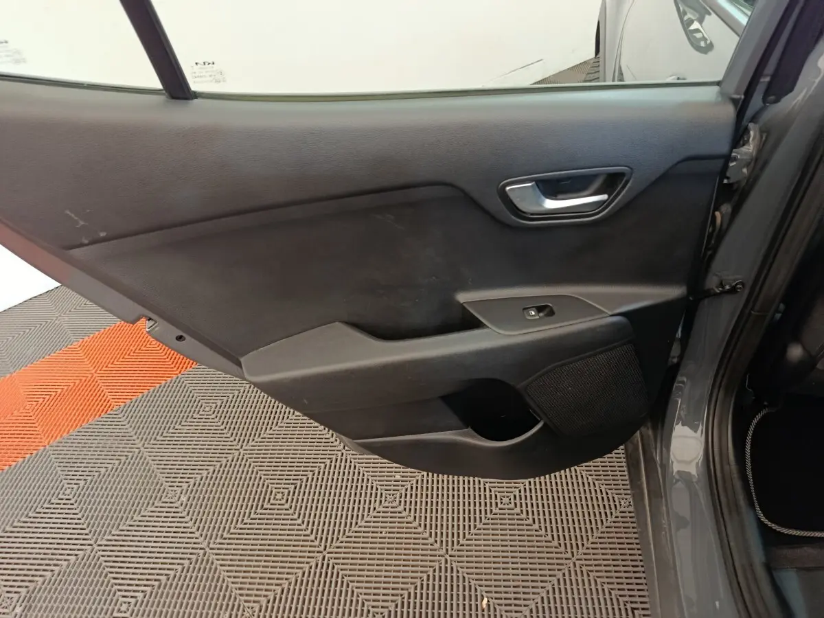 Vue intérieure de la porte arrière droite gris foncé du Kia Stonic 2023 avec poignée et commande de fenêtre.