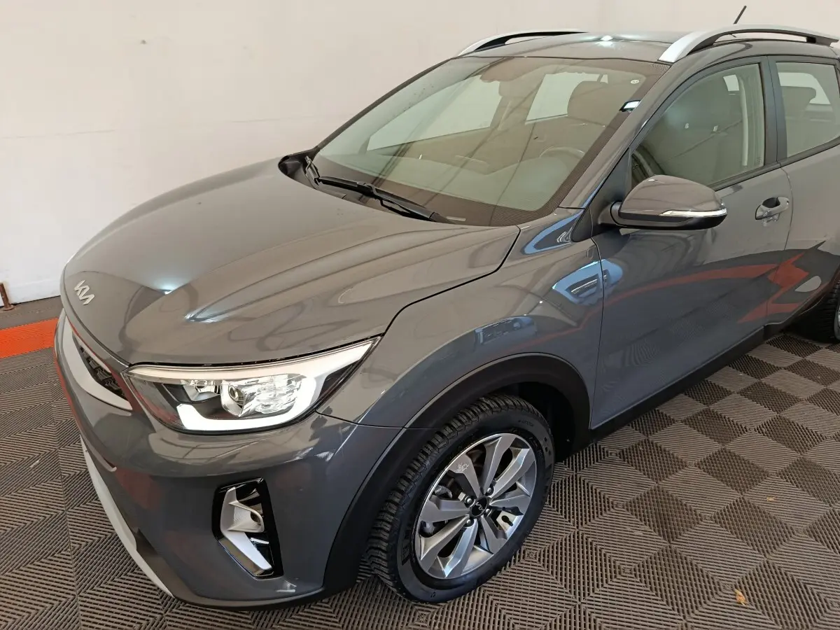 Vue 3/4 avant droite du KIA STONIC 1.0 T-GDI 100 Urban gris foncé avec phares ellipsoïdaux et jantes alliage.