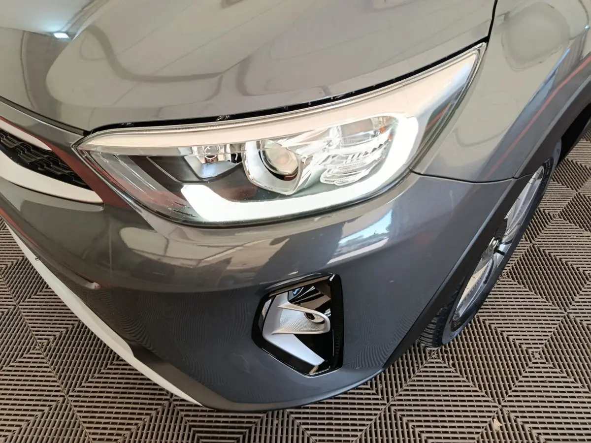 Gros plan sur l'avant droit gris foncé du KIA Stonic 2023, mettant en valeur le phare et le feu antibrouillard.
