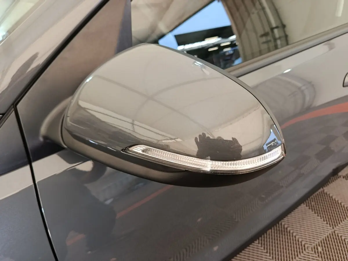 Rétroviseur côté gauche gris foncé de la KIA Stonic 2023 avec clignotant intégré, vue rapprochée en extérieur.