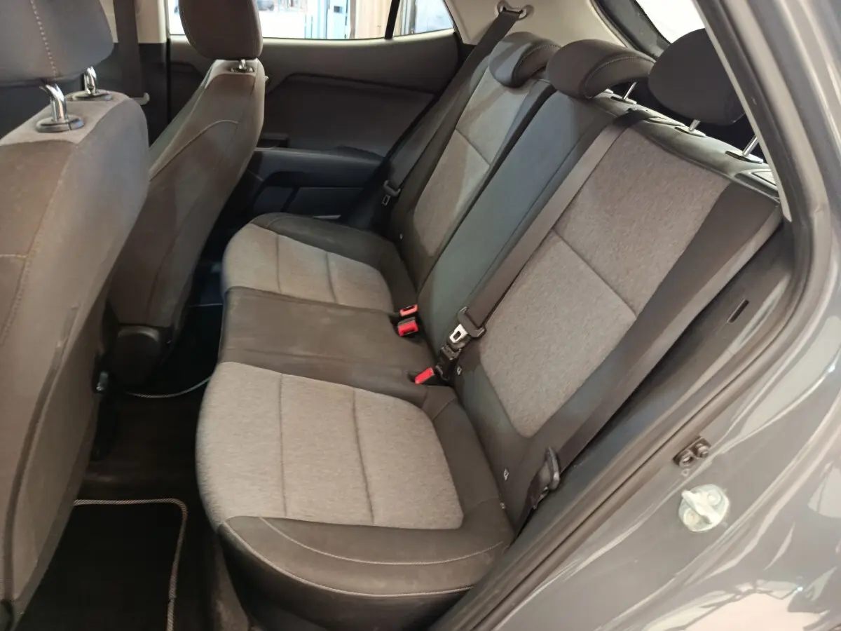 Vue intérieure côté droit des sièges arrière gris clair et foncé du KIA STONIC 2023, porte ouverte sur carrosserie gris foncé.