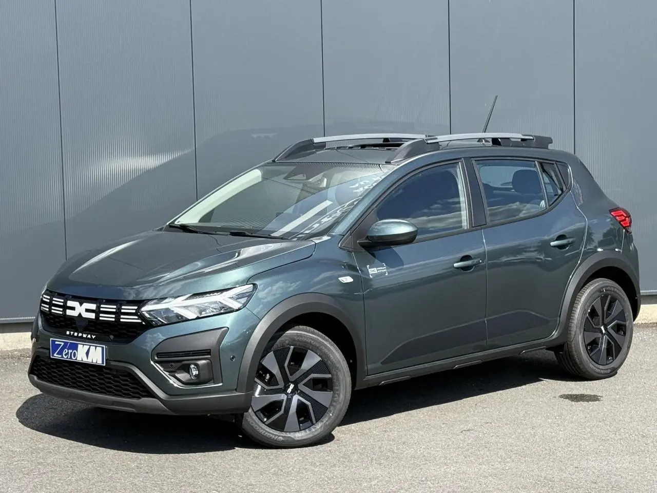 Dacia Sandero Stepway Vert Cèdre en 3/4 avant droit avec toit ouvrant et jantes 16 pouces noires.