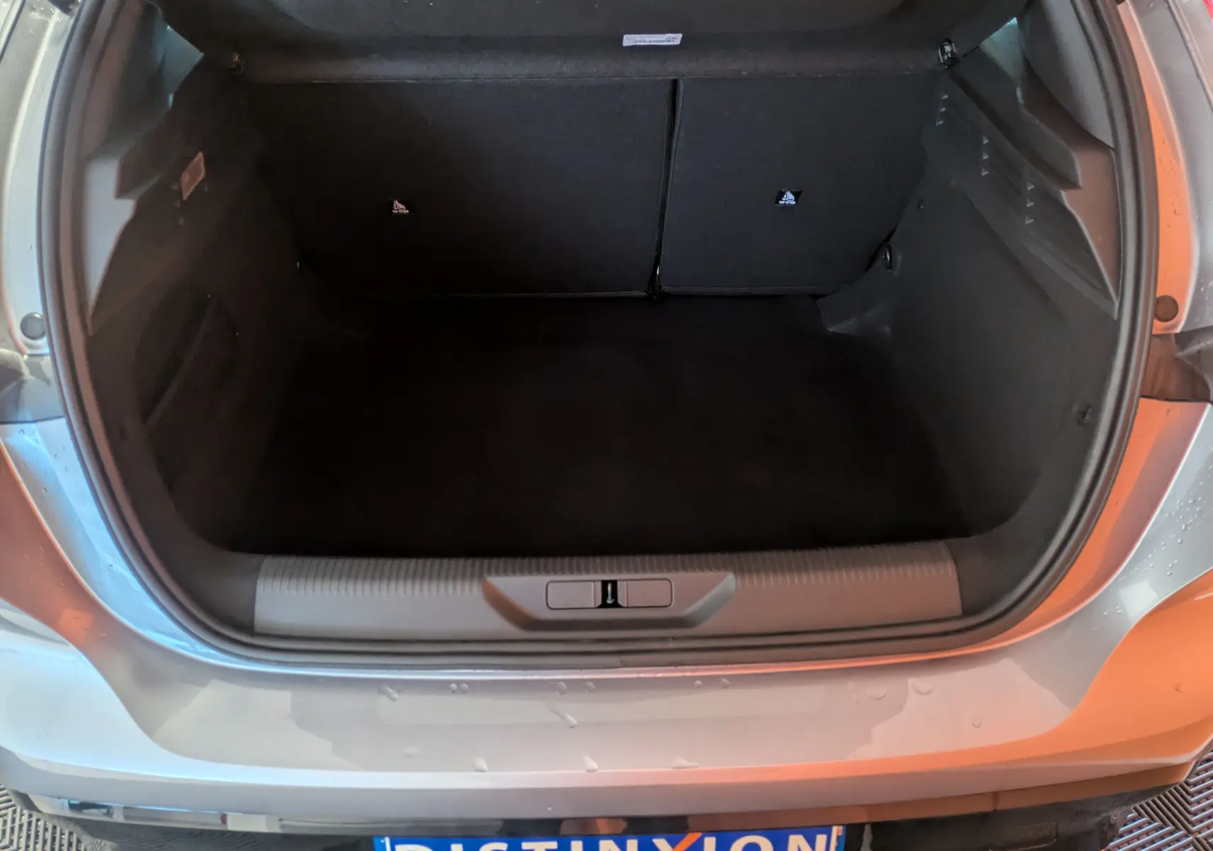 Coffre ouvert vu de l'arrière d'une Peugeot 308 2025 gris Artense, montrant l'espace de chargement vide.