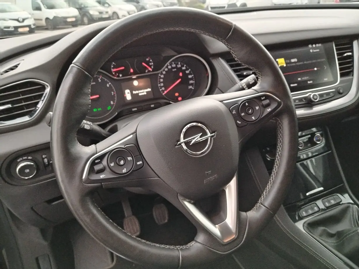 Vue rapprochée du volant en cuir noir de l'Opel Grandland X 2019 avec tableau de bord et console centrale visibles.
