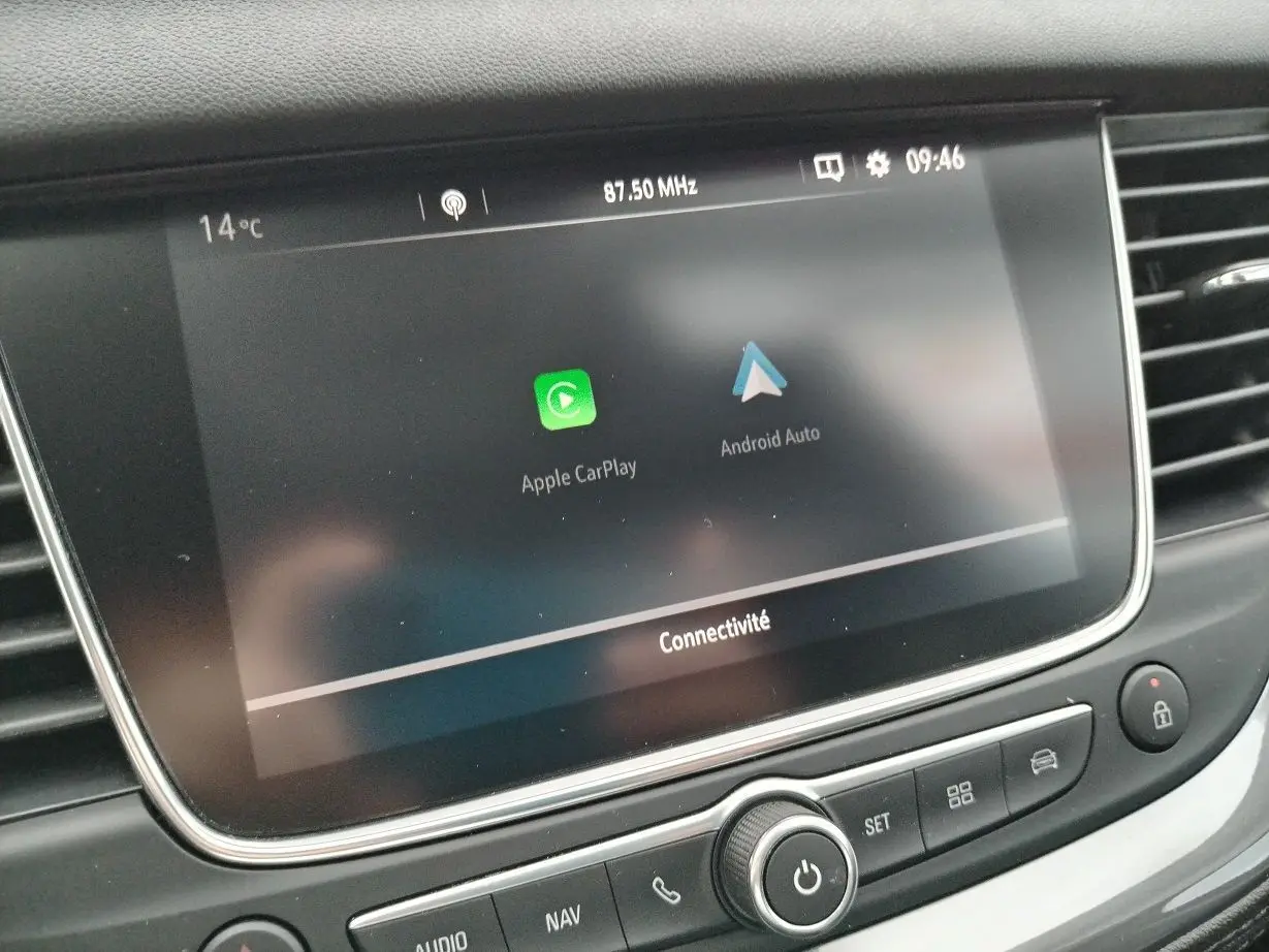 Écran tactile central affichant Apple CarPlay et Android Auto dans l'habitacle d'un Opel Grandland X gris platinium.