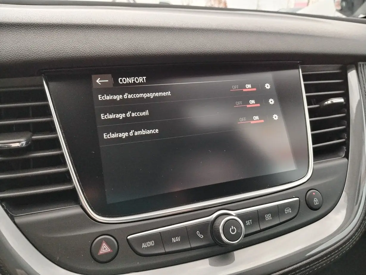 Écran tactile central de l'Opel Grandland X 2019 affichant les réglages d'éclairage confort, entouré de commandes noires.