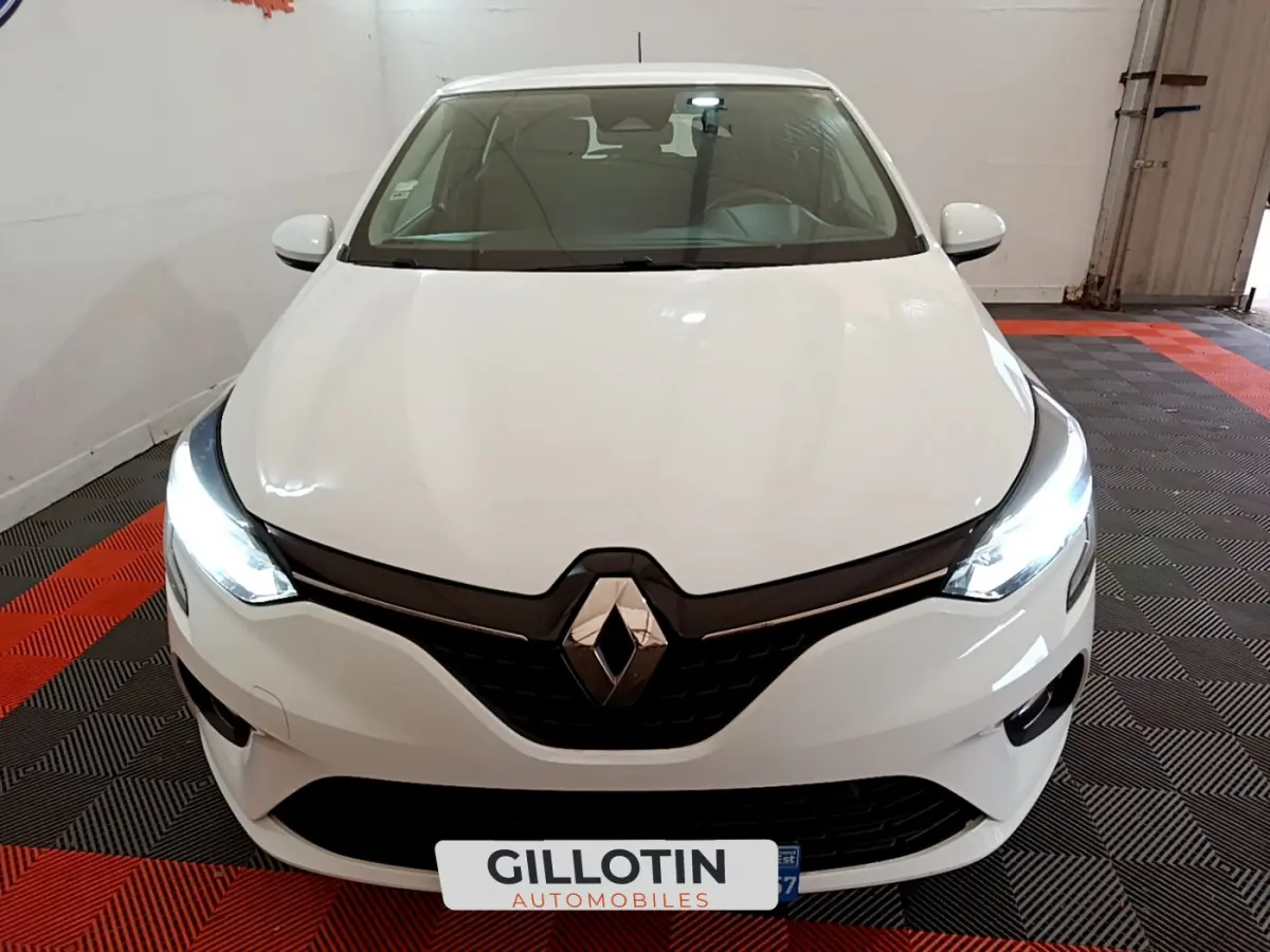 Renault Clio Business Blue dCi 85 blanche vue de face avec phares LED allumés dans un garage.