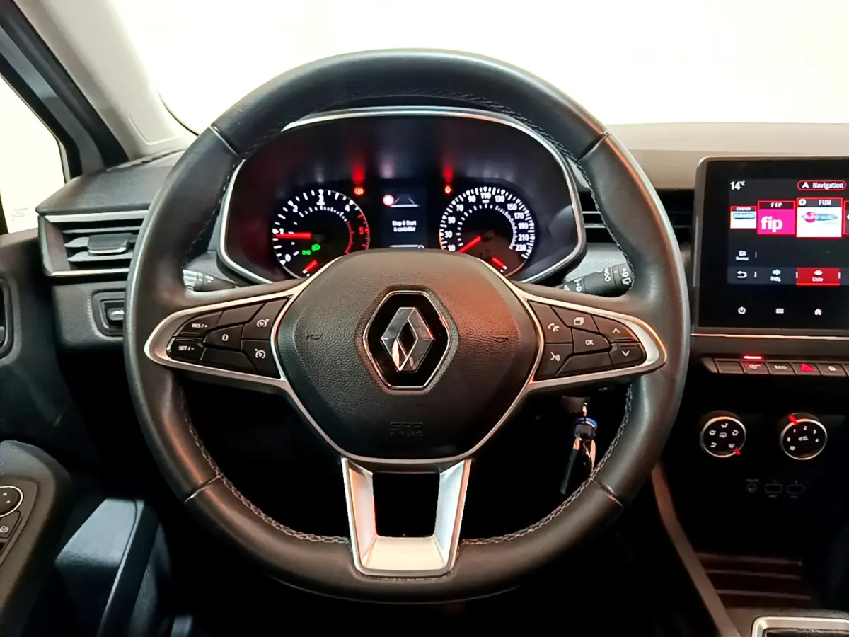 Vue rapprochée du volant en cuir noir de la Renault Clio Business Blue dCi 85 2020 avec tableau de bord et écran tactile.