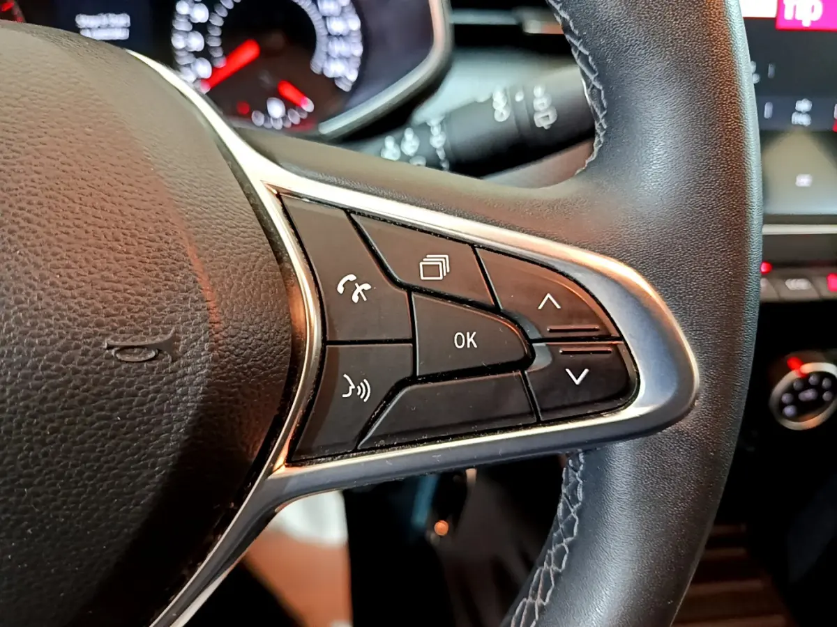 Gros plan sur les commandes multifonctions du volant cuir noir de la Renault Clio Business Blue dCi 85 de 2020.