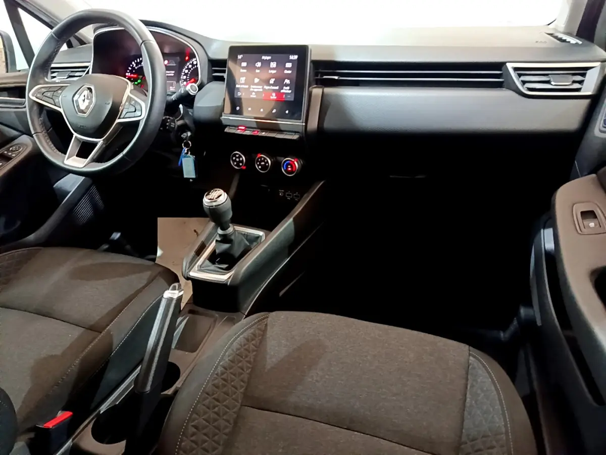 Intérieur avant droit de la Renault Clio Business Blue dCi 85 2020, volant cuir, écran tactile et levier de vitesse manuel visibles.
