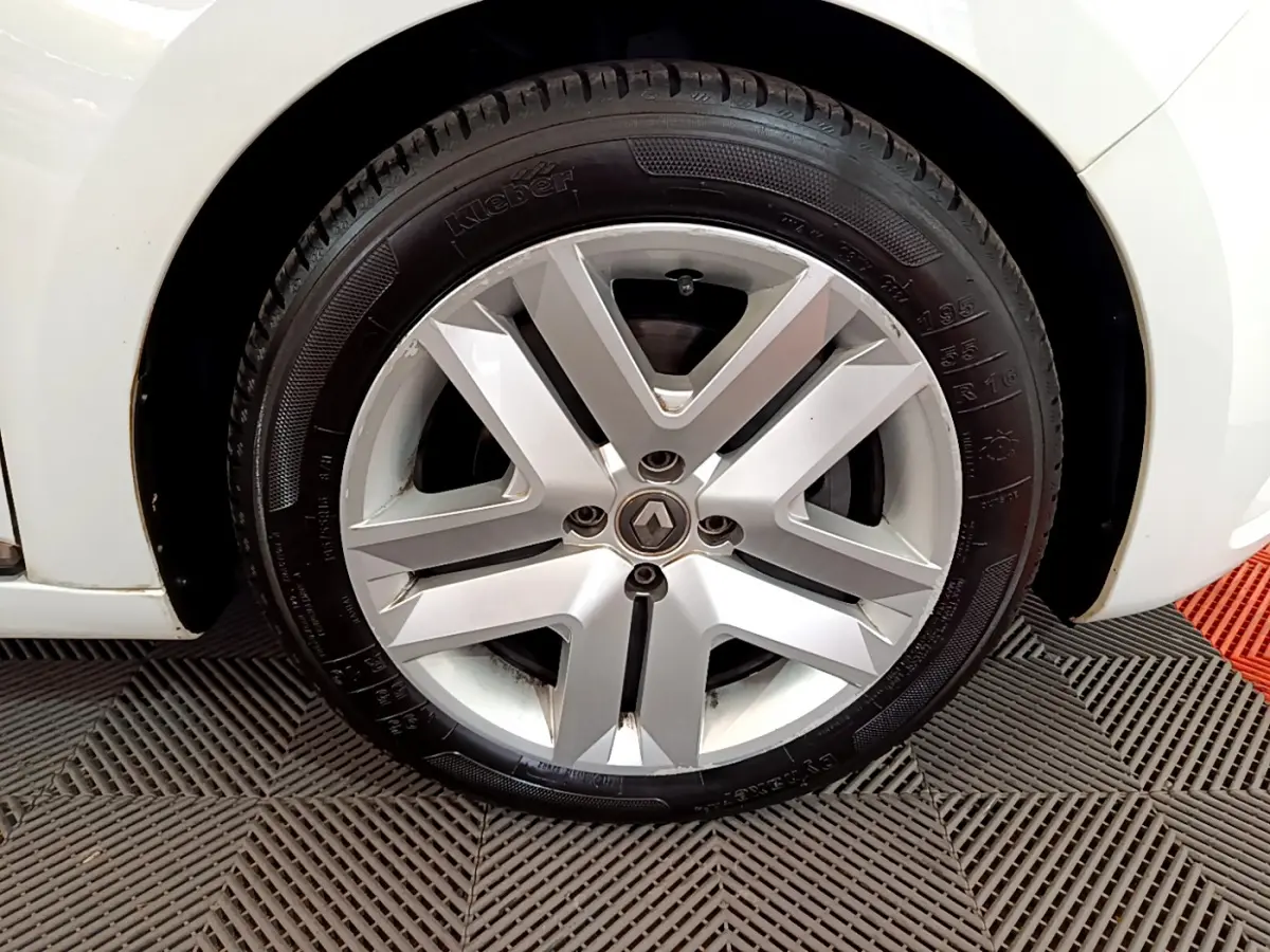 Gros plan sur la roue avant gauche blanche d'une Renault Clio Business Blue dCi 85 avec jante alliage argentée.