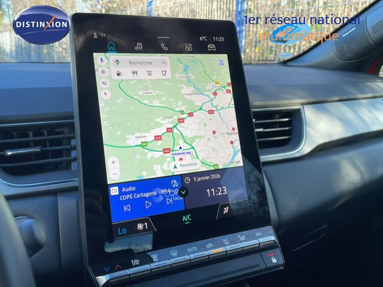 Vue rapprochée de l’écran tactile central du tableau de bord du Renault Captur rouge Désir Métal, affichant la navigation GPS.