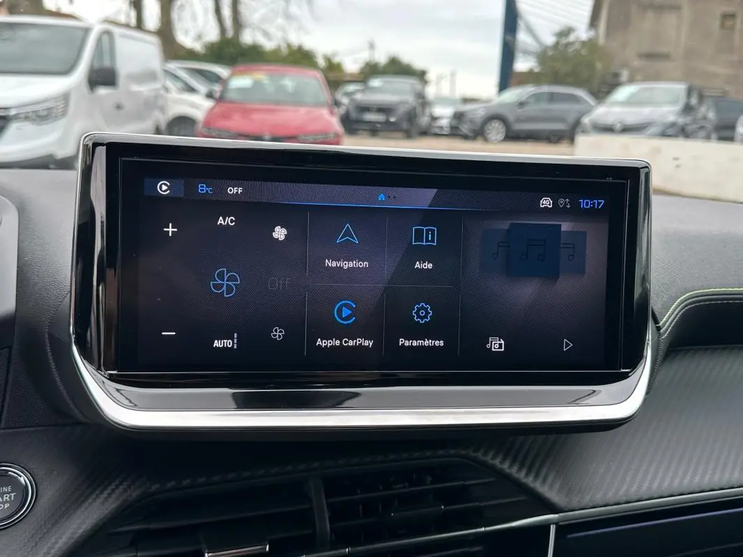 Vue intérieure centrée sur l'écran tactile du tableau de bord de la Peugeot 208 gris 2025, affichant les options de navigation et connectivité.
