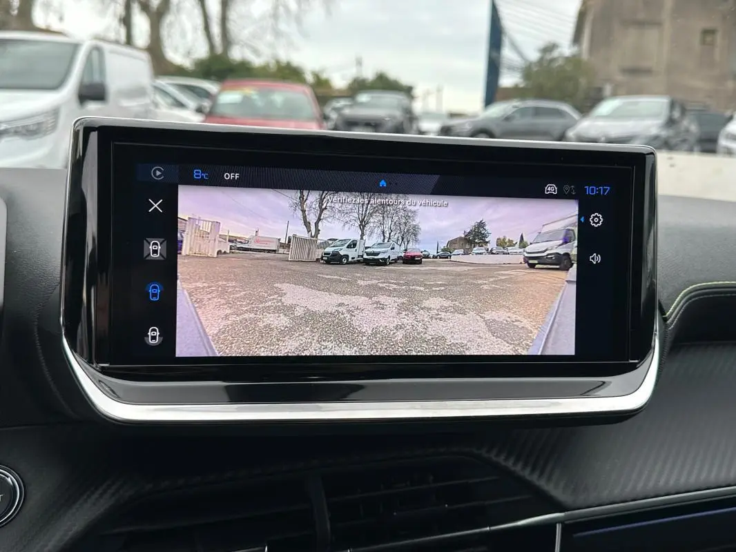 Écran tactile intérieur montrant la caméra de recul d'une Peugeot 208 gris, vue du tableau de bord.