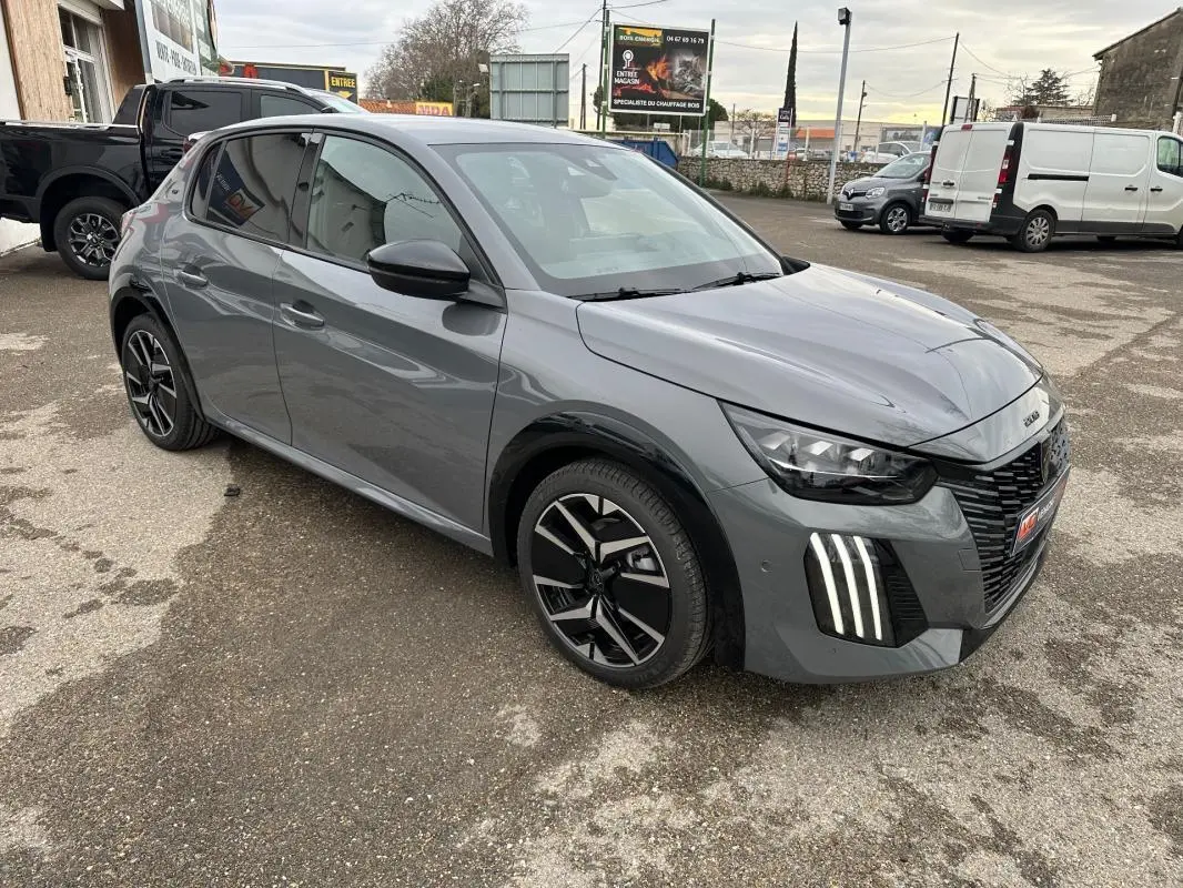 Peugeot 208 Hybrid 110 gris vue 3/4 avant droit, avec jantes alliage 17 pouces et feux LED verticaux distinctifs.