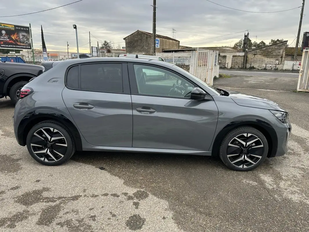 Vue de profil côté gauche d'une Peugeot 208 Hybrid 110 e-DCS6 GT gris avec jantes alliage 17 pouces et rétroviseurs noirs.