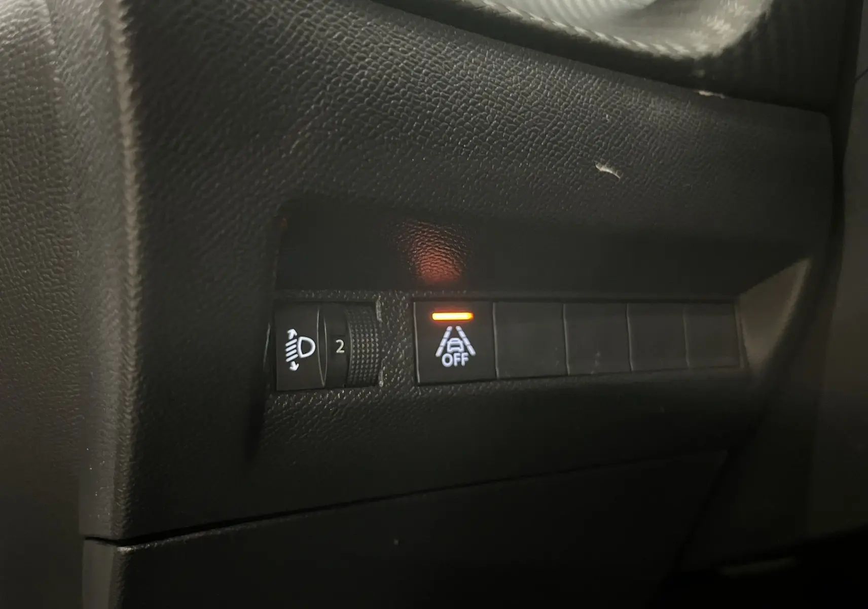 Gros plan sur les commandes intérieures noires du Peugeot 2008 Active Business, avec témoin d'alerte orange allumé.