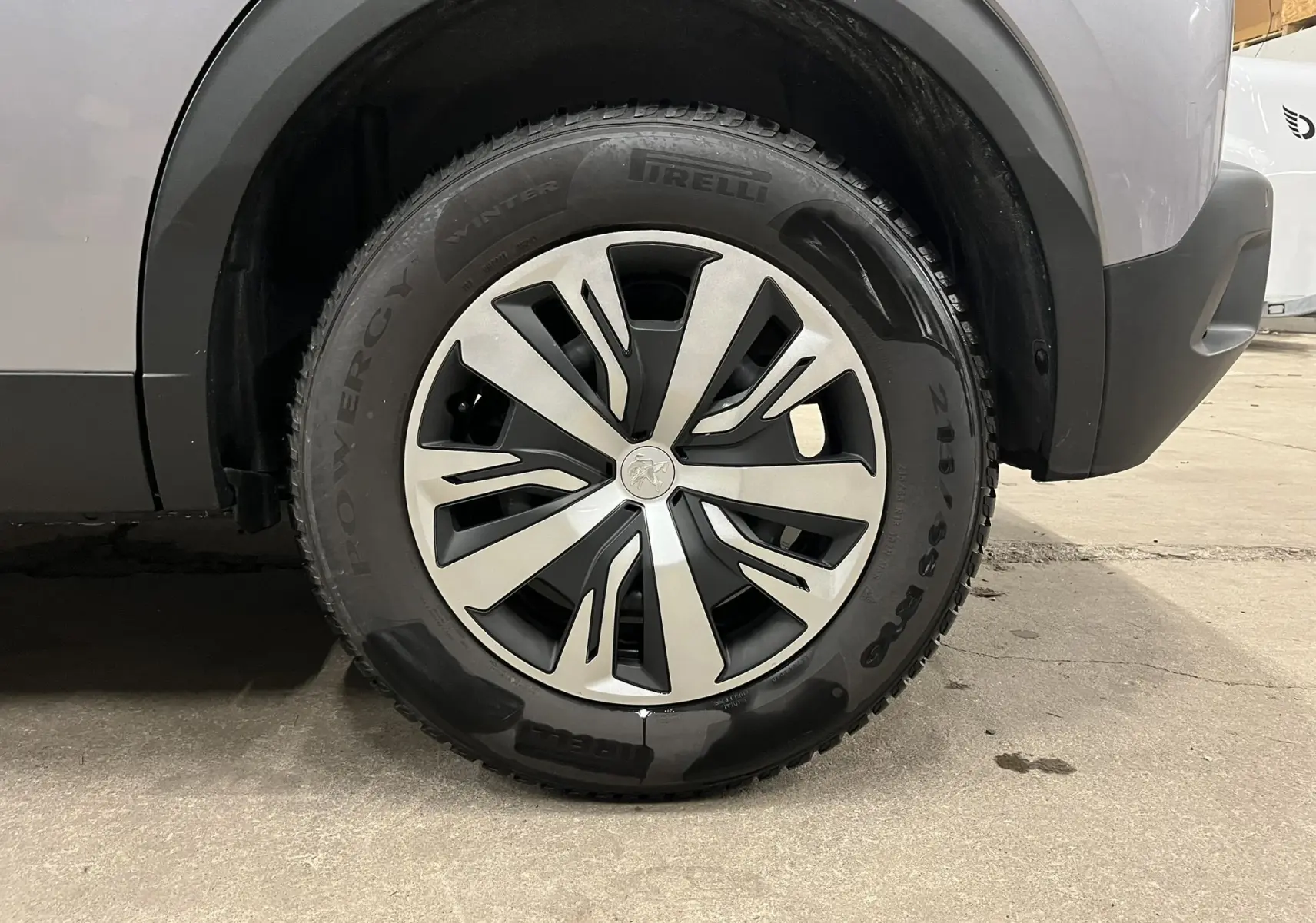 Gros plan sur la roue avant droite du Peugeot 2008 gris alu, mettant en valeur la jante et le pneu hiver Pirelli.