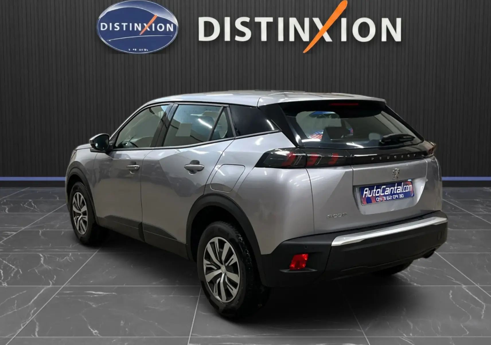 Peugeot 2008 gris alu vue 3/4 arrière droit, mettant en valeur les feux arrière et le design compact du SUV.
