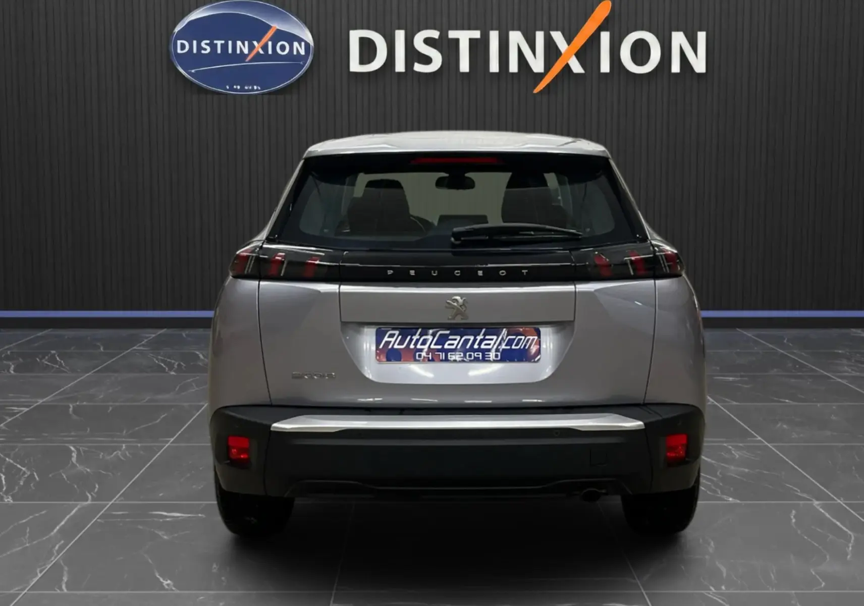 Vue arrière d'un Peugeot 2008 gris alu 2020, avec feux arrière en bandeau noir et logo lion centré.
