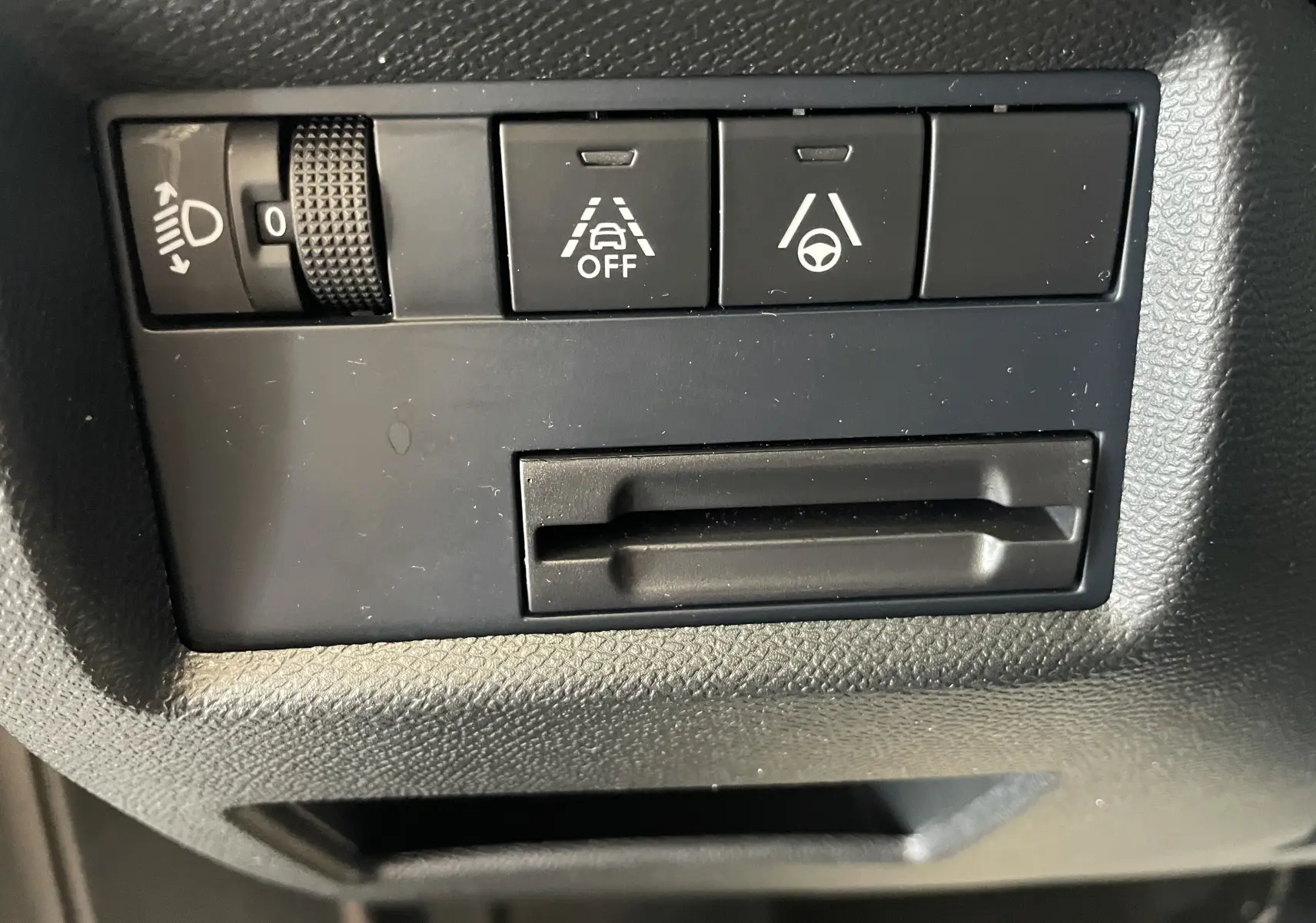 Gros plan sur les commandes noires du tableau de bord du Citroën C5 Aircross hybride gris platinium, boutons d'assistance à la conduite.