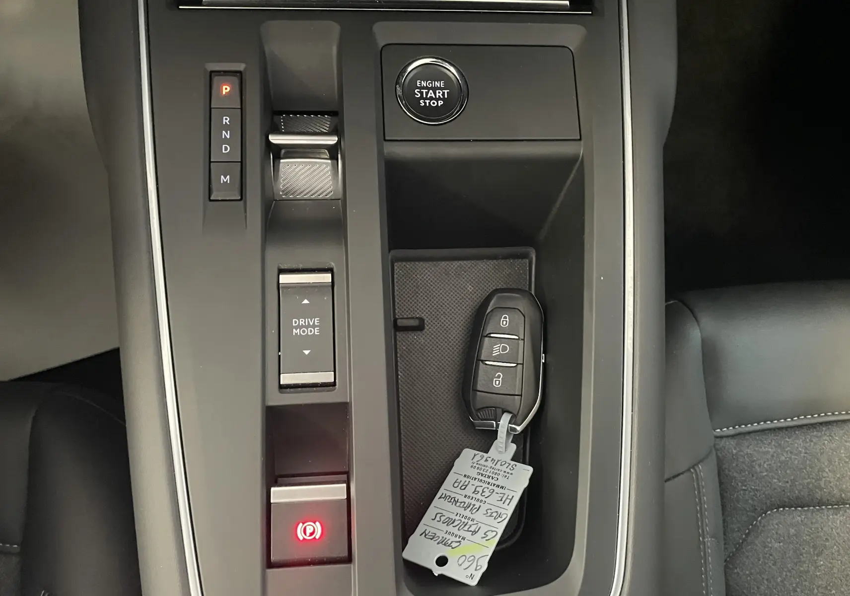 Vue en plongée sur la console centrale de la Citroën C5 Aircross hybride 2025, avec clé et bouton start/stop visibles.