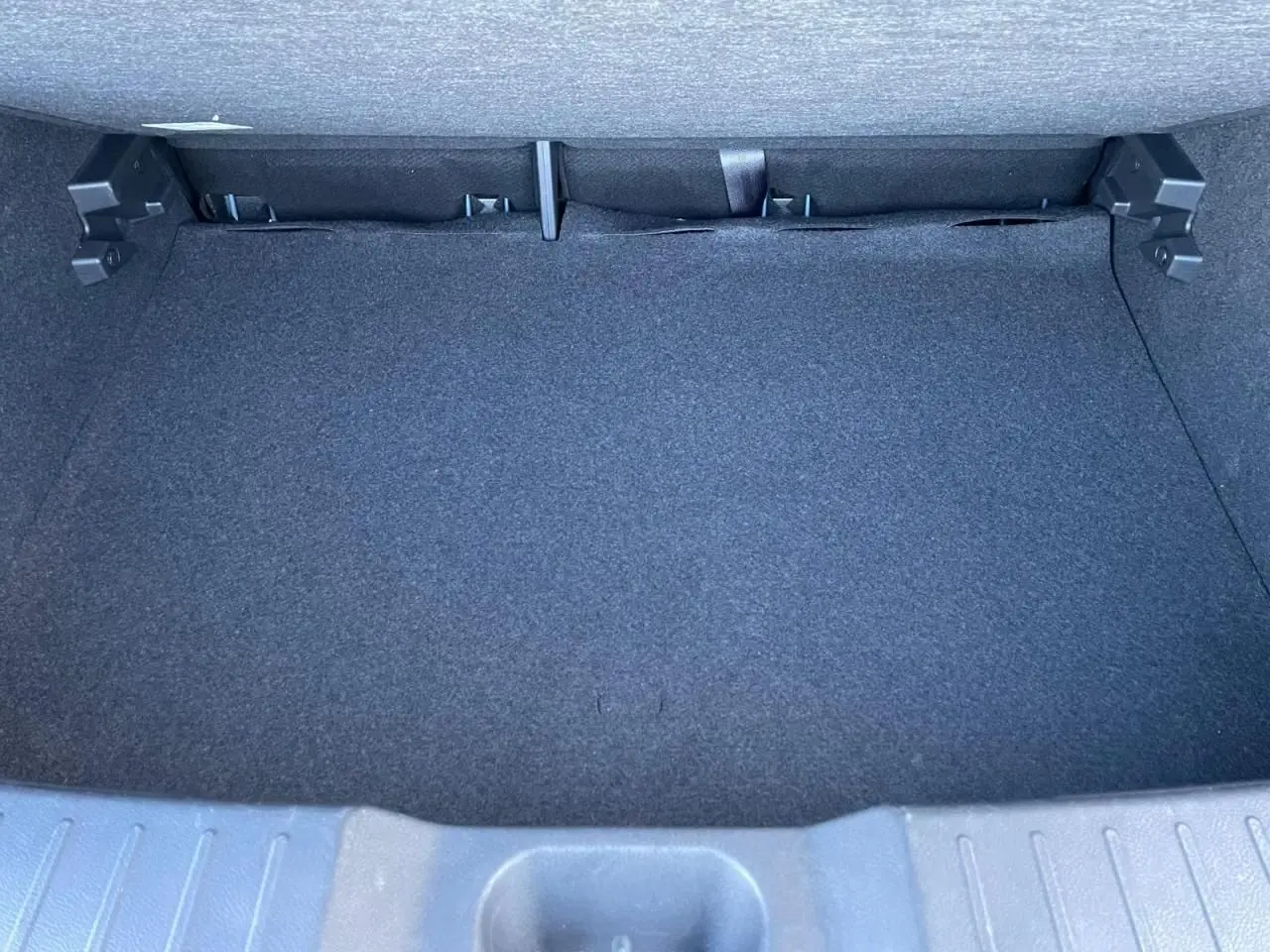 Coffre vide du Nissan Juke II 2024, vue intérieure arrière avec revêtement noir et plancher plat.