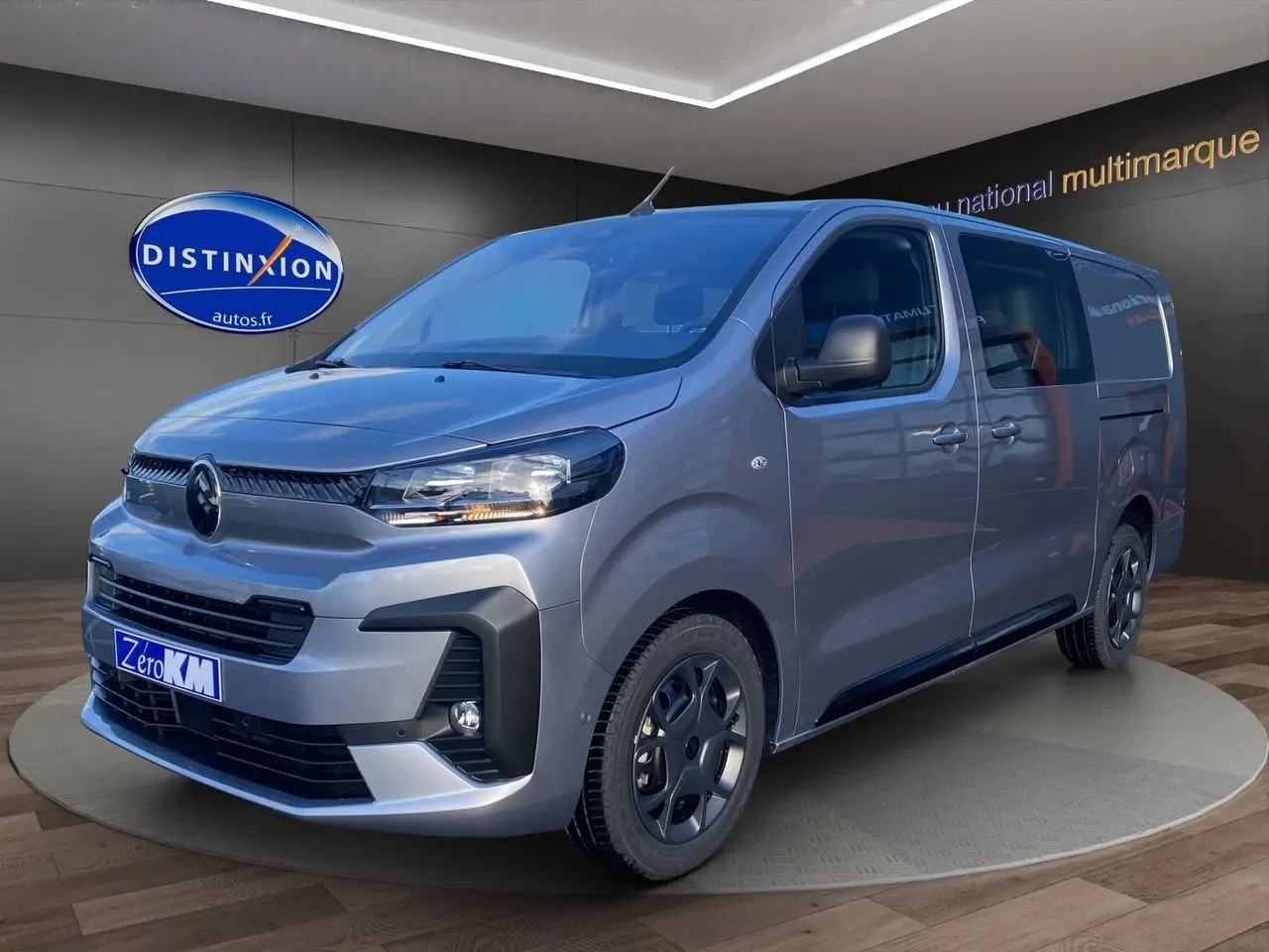 Vue 3/4 avant droite du Citroën Jumpy Cabine Approfondie gris acier avec jantes noires et projecteurs allumés.