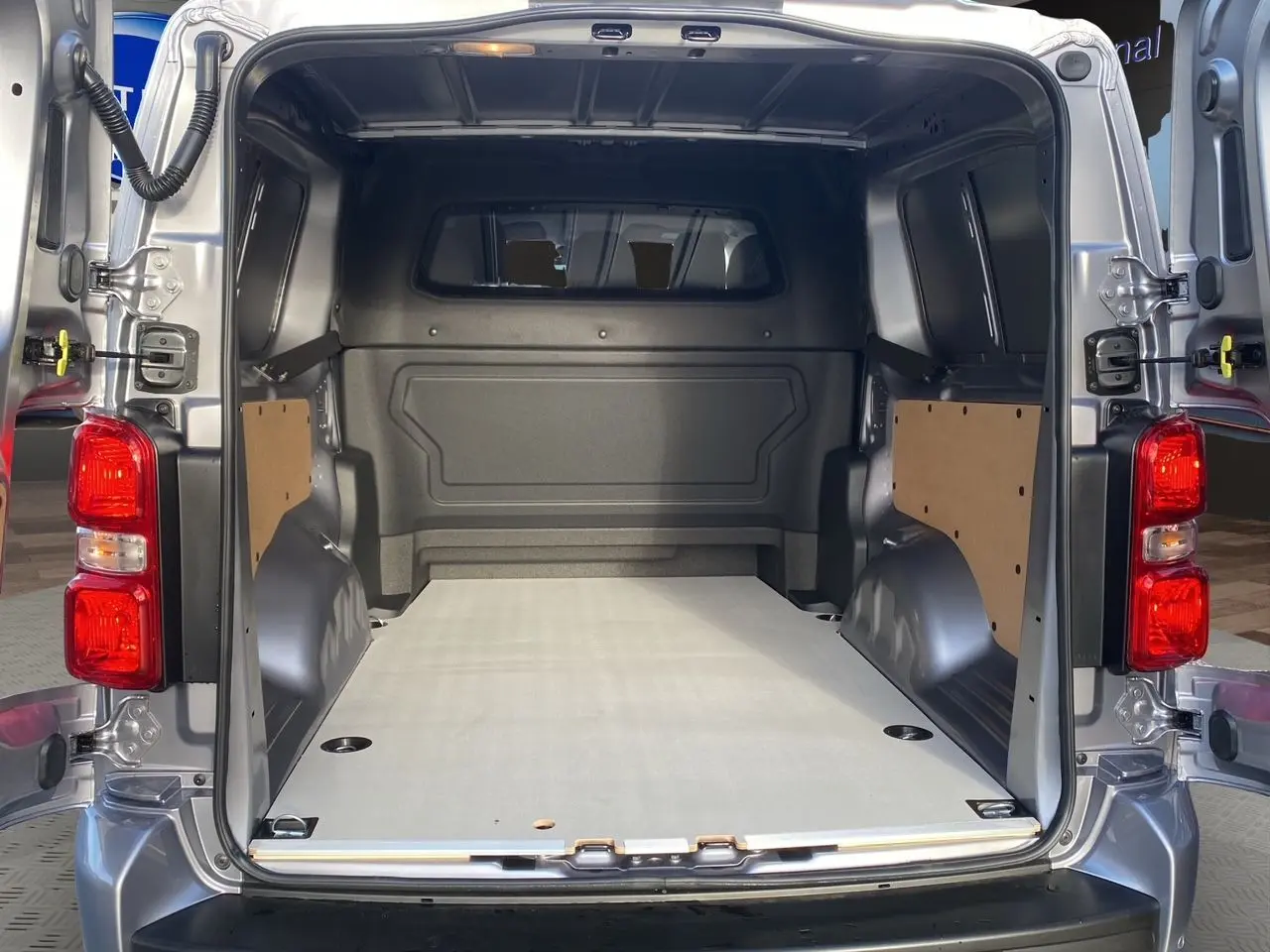Vue arrière ouverte du Citroën Jumpy cabine approfondie gris acier, montrant l'espace de chargement avec plancher bois.