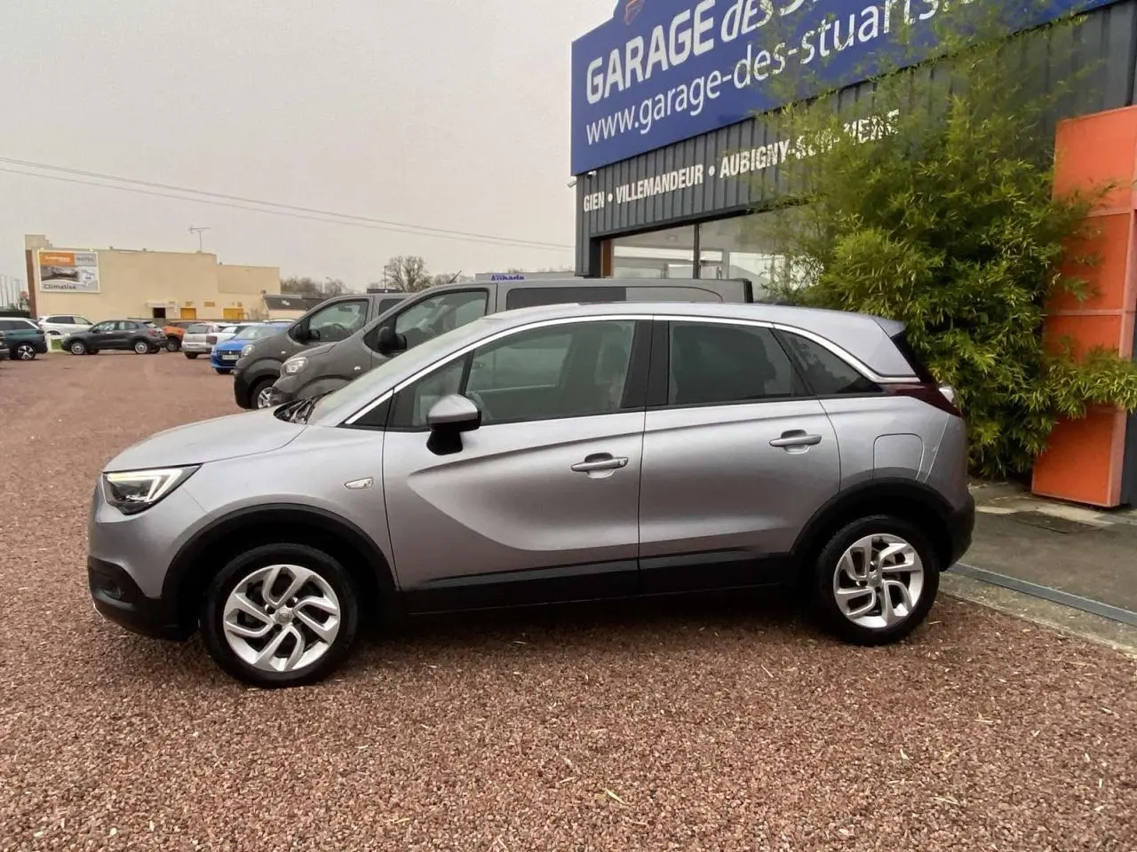 Opel Crossland X gris métallisé vu de profil côté gauche, avec jantes alliage 16 pouces Twin Spoke.
