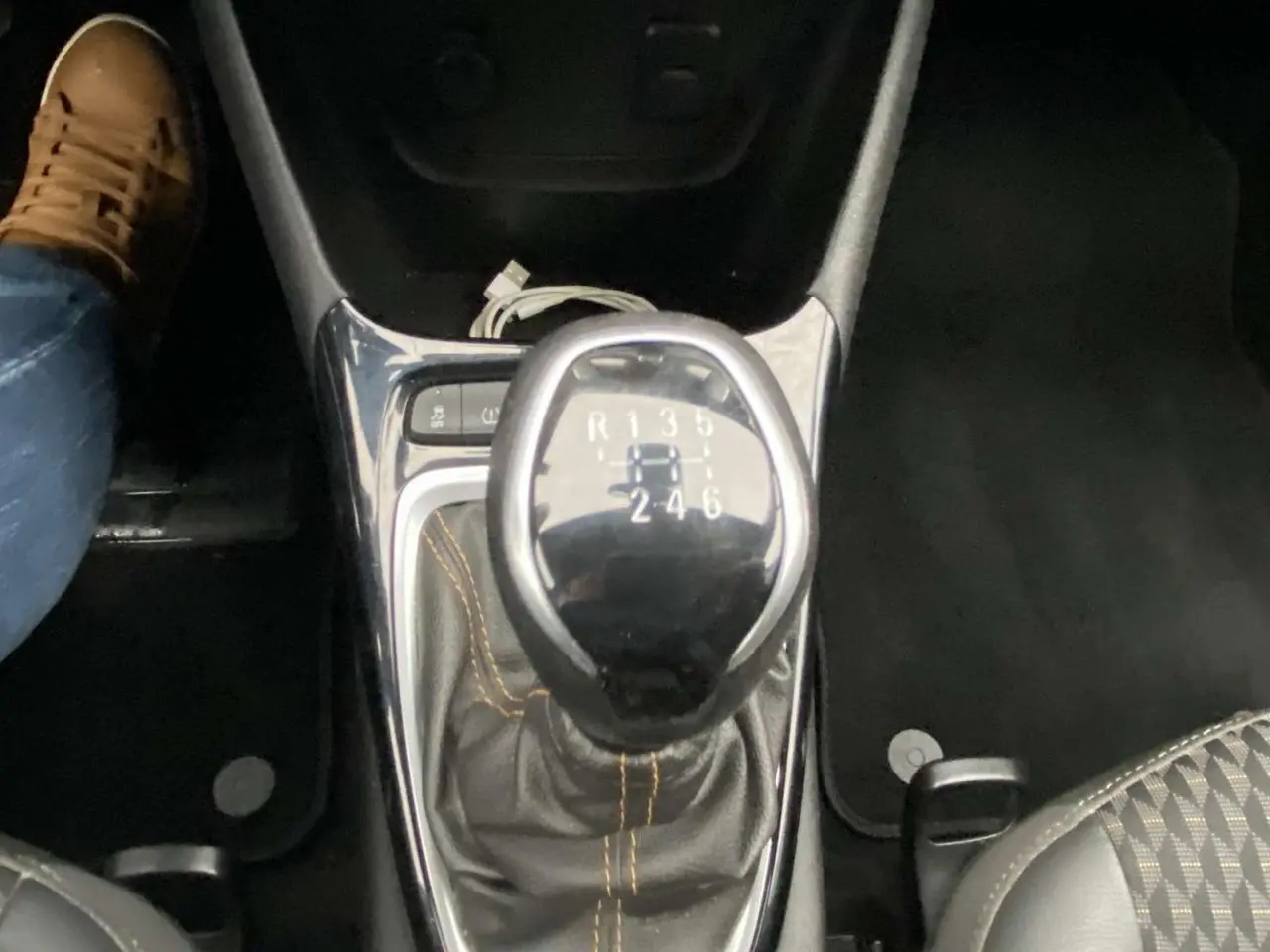 Le levier de vitesses manuel noir avec coutures orange de l'Opel Crossland X Elégance vue en gros plan intérieur.