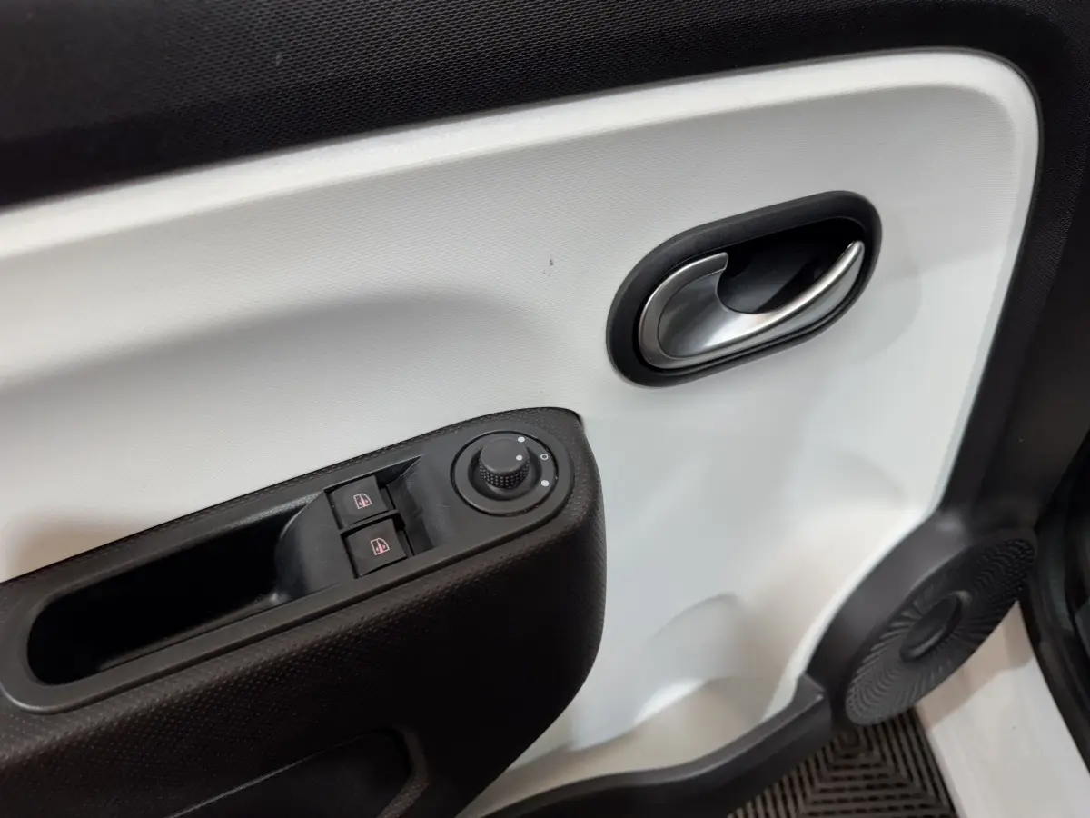 Gros plan sur la porte intérieure blanche côté conducteur de la Renault Twingo Equilibre 2022 avec commandes de vitres et rétroviseurs.