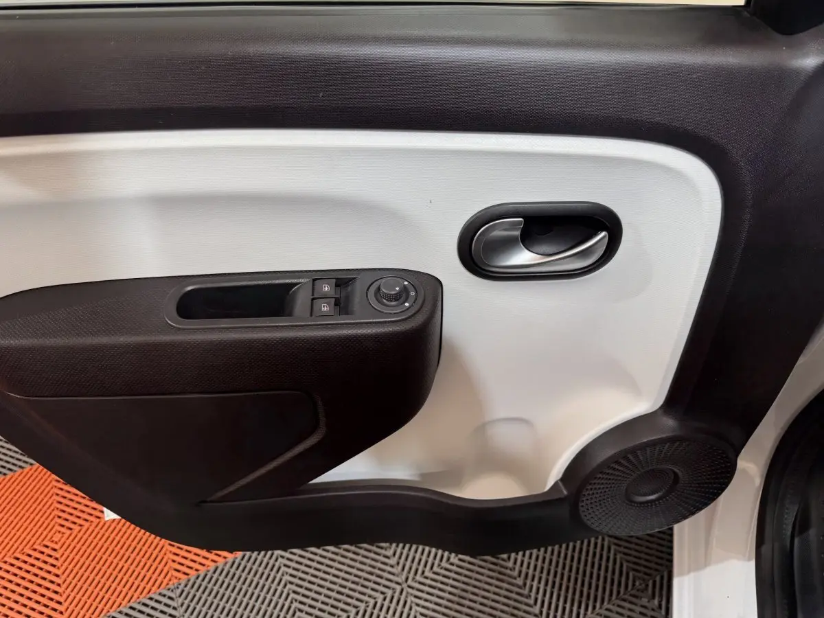 Gros plan sur la porte avant gauche blanche de la Renault Twingo 2022 avec commandes de vitres et haut-parleur intégré.