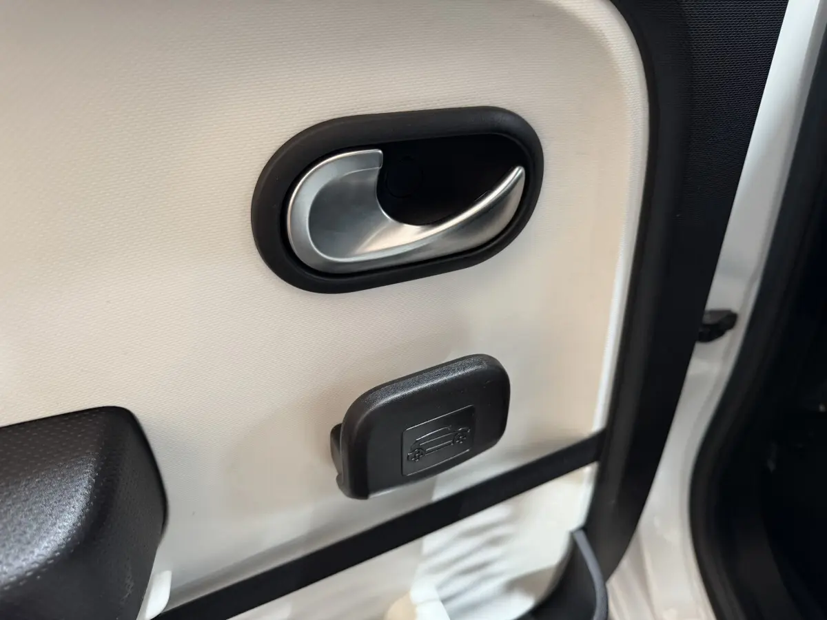 Gros plan sur la poignée intérieure de porte blanche côté conducteur d'une Renault Twingo Equilibre 2022.