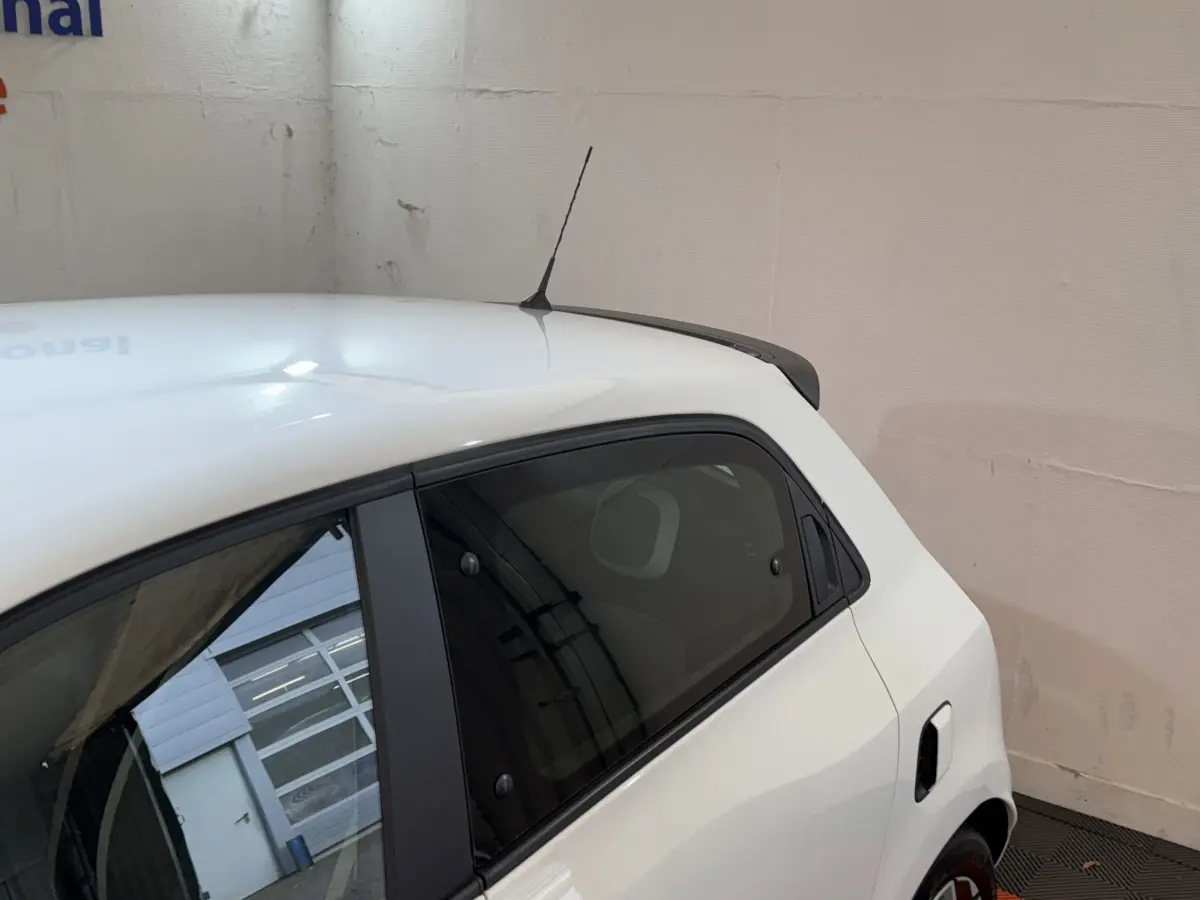 Vue côté gauche arrière d'une Renault Twingo blanche 2022 avec antenne de toit et vitre teintée arrière