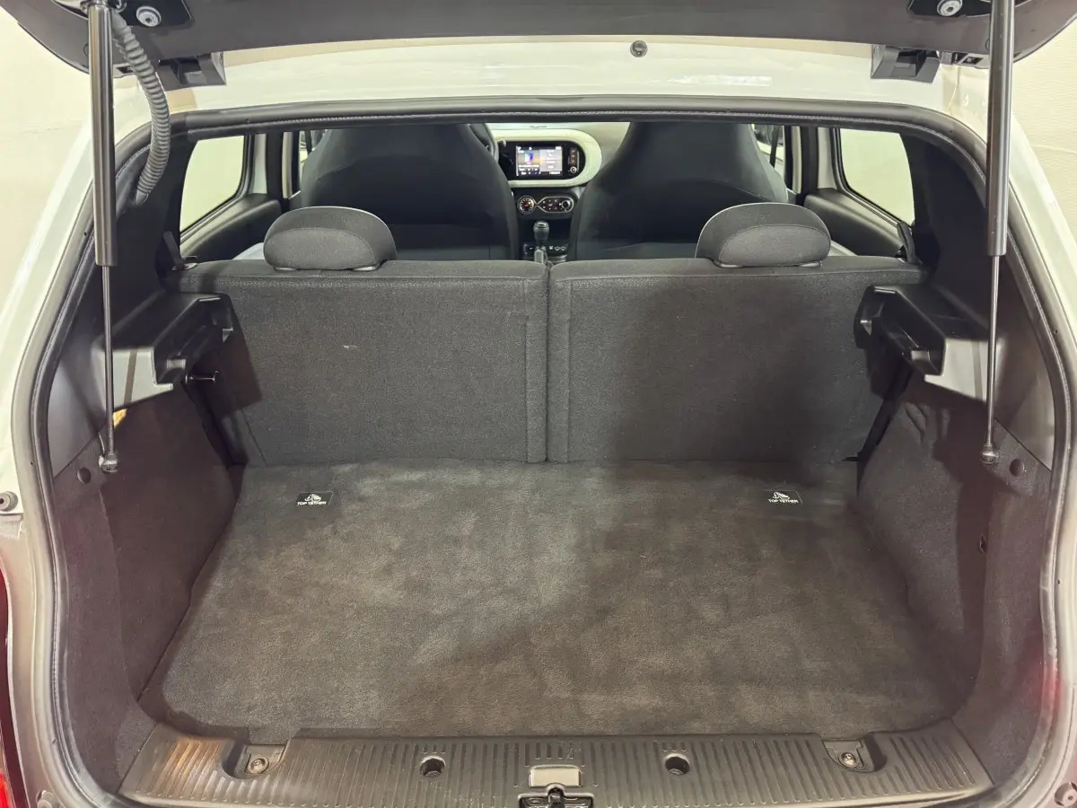 Coffre ouvert vu de l'arrière d'une Renault Twingo blanche 2022, montrant la banquette arrière et l'intérieur noir.