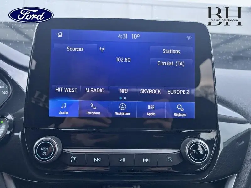 Écran tactile central du Ford Puma 2020 affichant les options audio et navigation, avec commandes physiques en dessous.