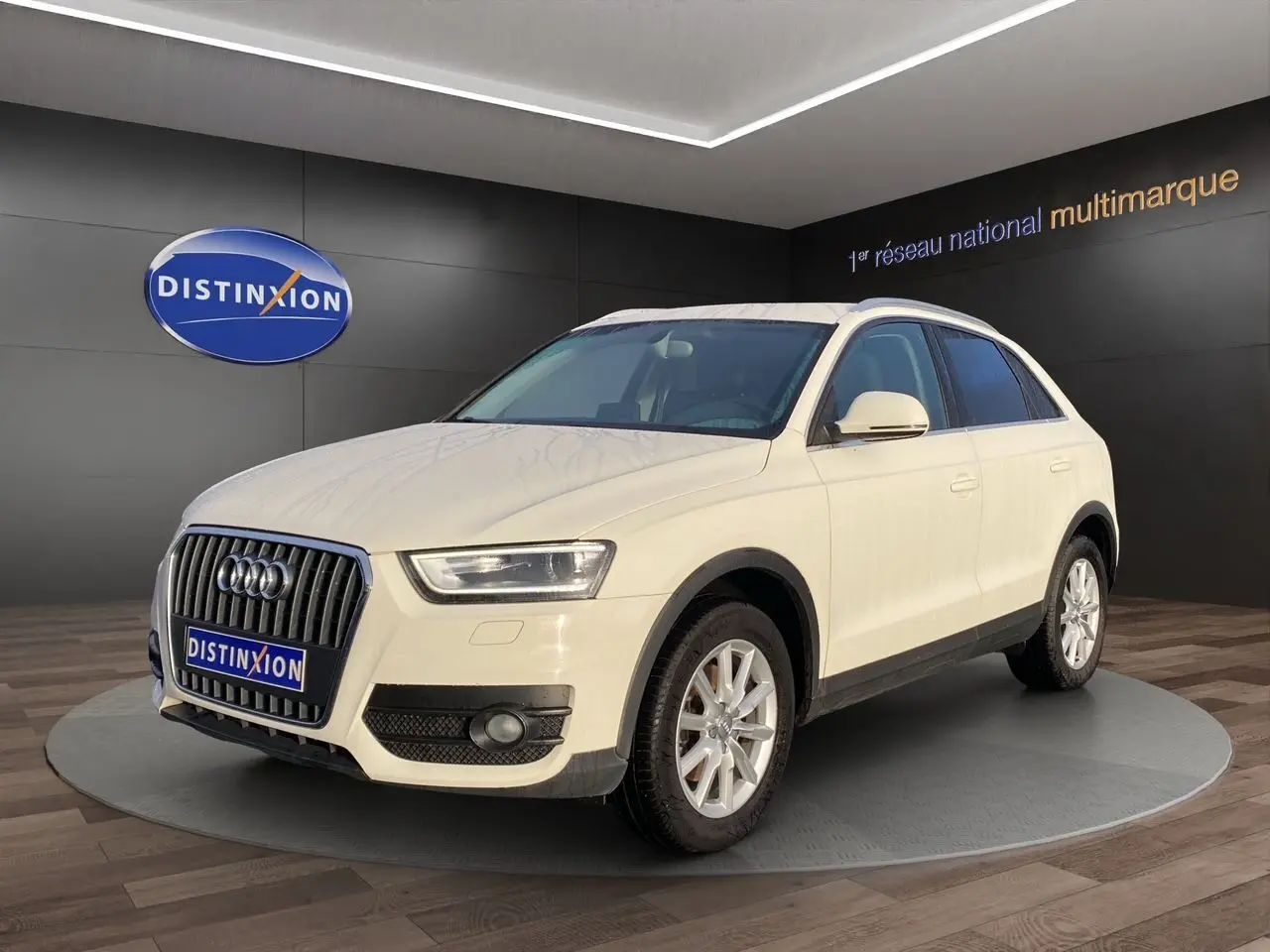 Audi Q3 blanc en 3/4 avant droit avec vitres arrière surteintées, présenté en showroom Distinxion.