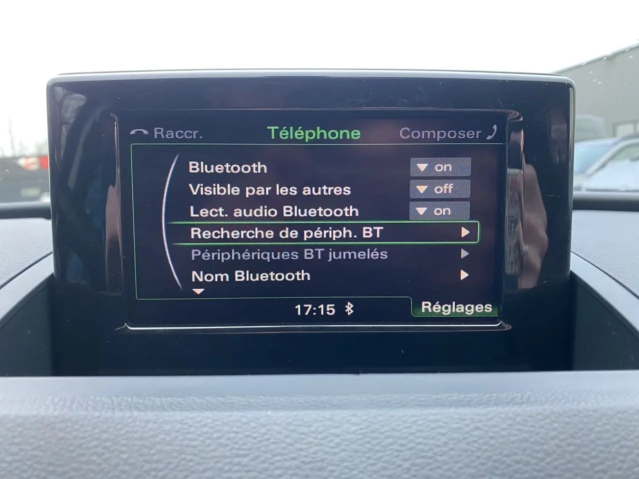 Écran GPS central affichant le menu Bluetooth dans l'habitacle d'un Audi Q3 blanc, vue de face.