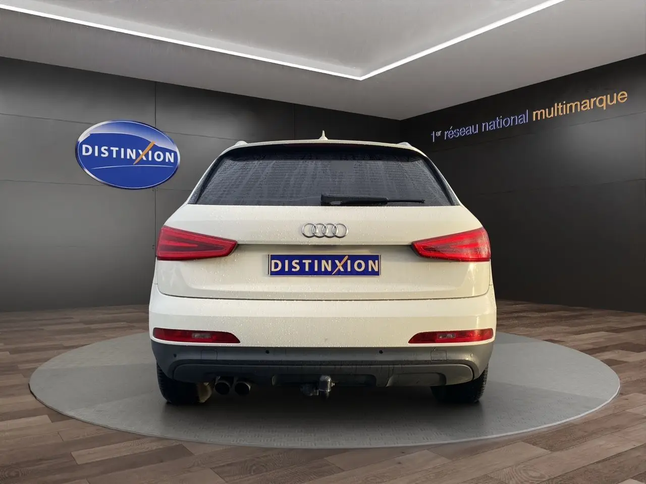 Vue arrière d'un Audi Q3 blanc 2014 avec vitres arrière surteintées et attelage visible.