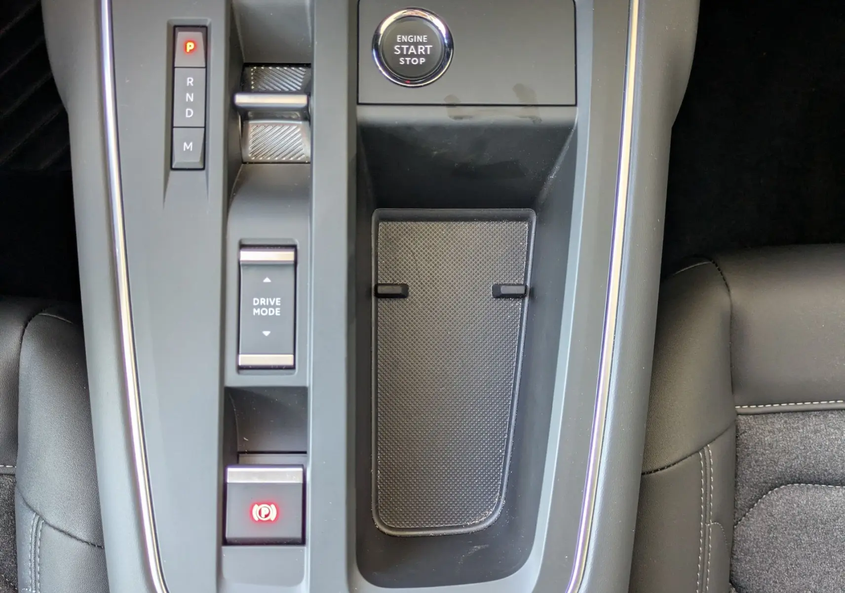 Vue plongeante sur la console centrale noire du Citroën C5 Aircross hybride 2025 avec bouton start/stop et commandes de boîte auto.