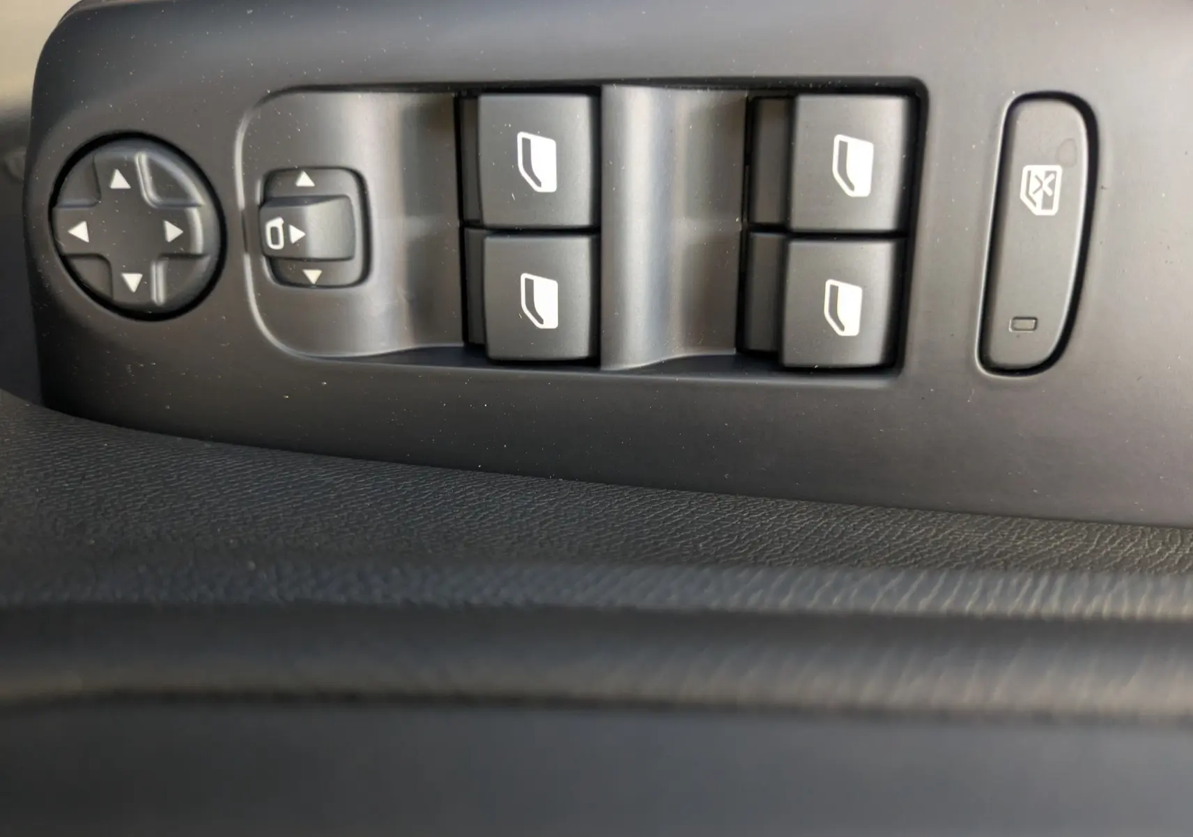 Panneau de commandes des vitres électriques et rétroviseurs sur la portière côté conducteur d'un Citroën C5 Aircross noir Perla.
