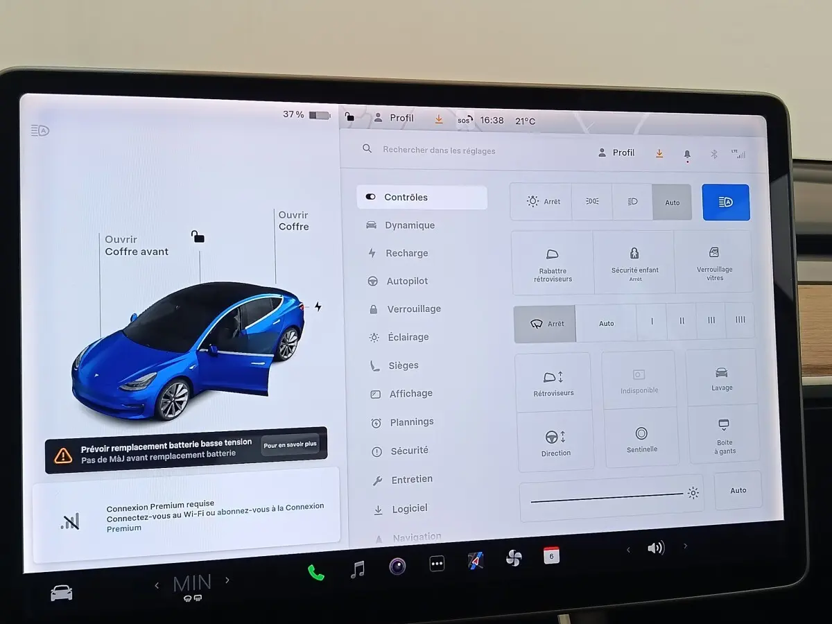 Écran tactile central montrant une Tesla Model 3 bleu en vue 3/4 avant avec porte conducteur ouverte.