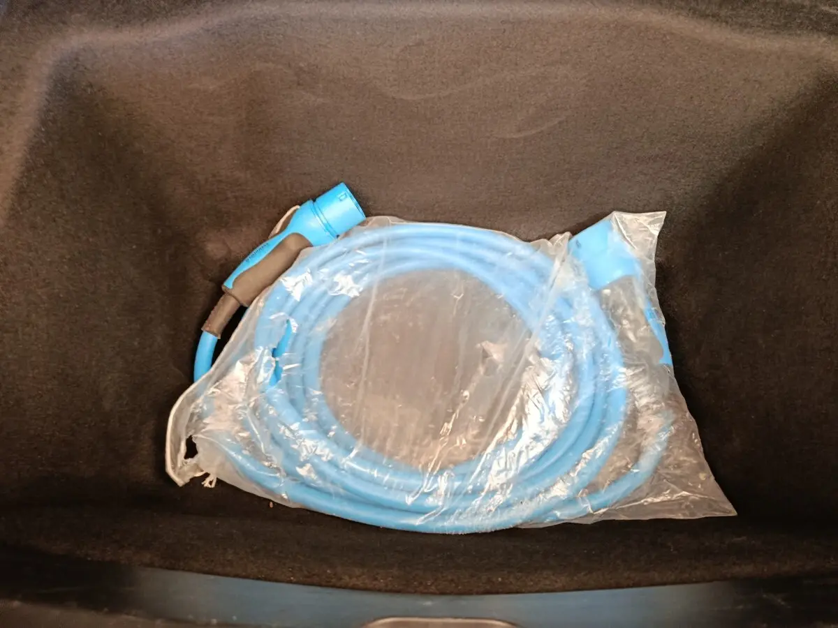 Câble de recharge bleu emballé dans le coffre avant d'une Tesla Model 3 Long Range 2020.