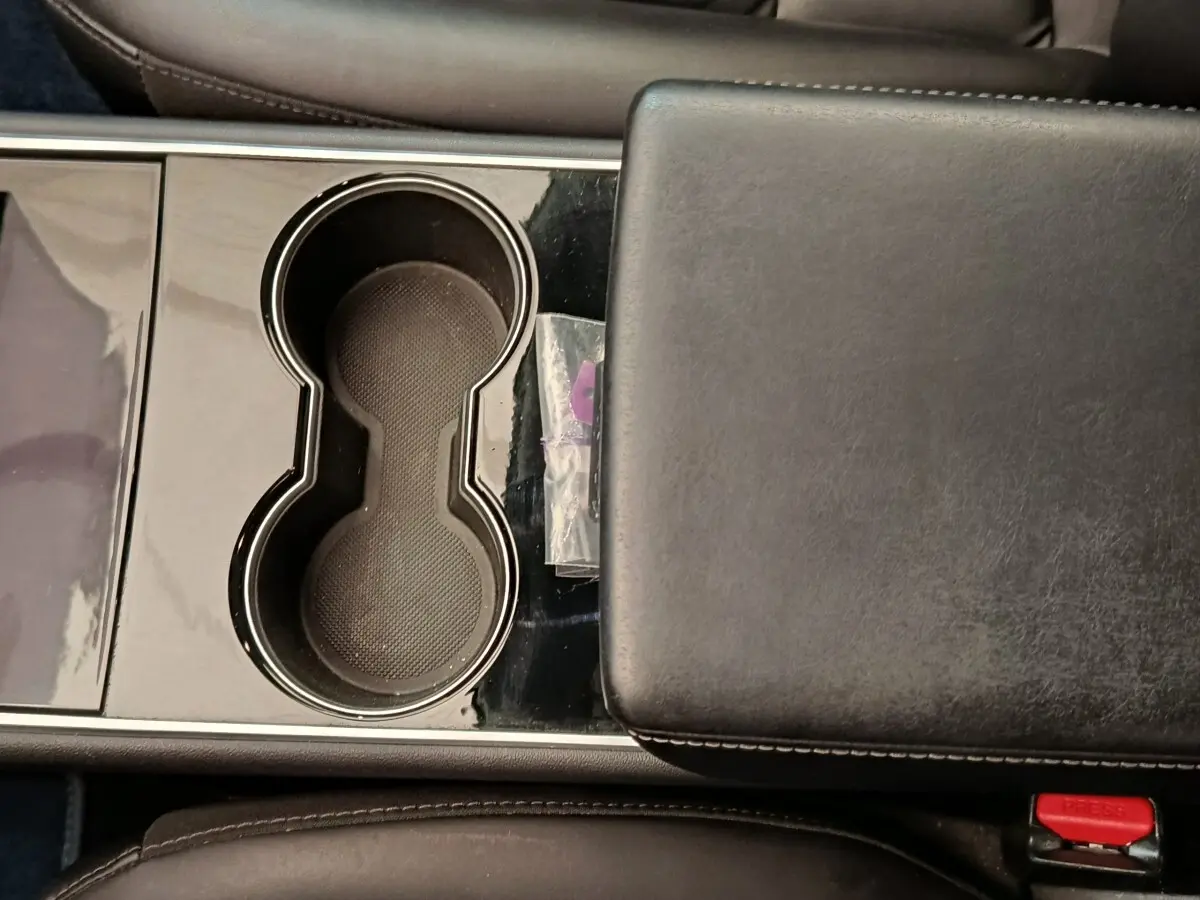 Gros plan sur la console centrale noire avec porte-gobelets et accoudoir en cuir du Tesla Model 3 Long Range 2020.